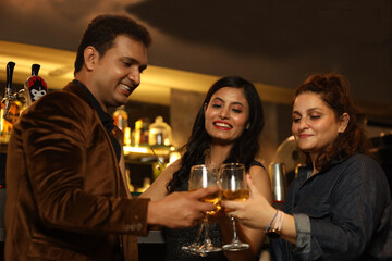 Indian group of friends enjoying evening drinks In bar