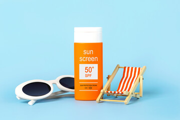 Closeup of white sunglasses, beach deck chair and bottle of sunscreen with 50+ written on it. Summer vacation concept