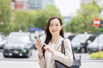 アプリでタクシーを予約する女性