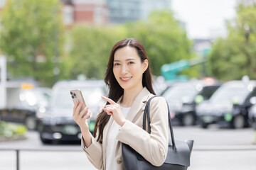 タクシーアプリで予約する女性