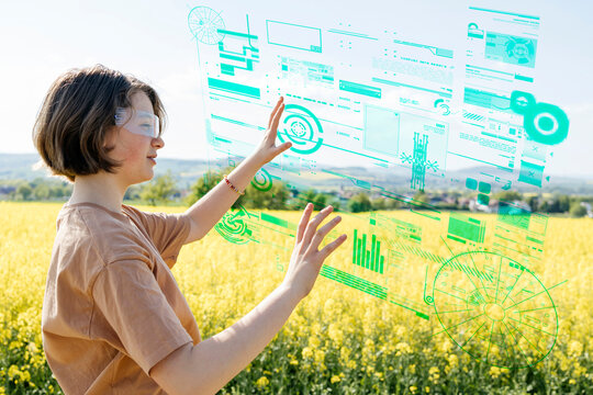 Girl using augmented reality technology with holographic interface in a field