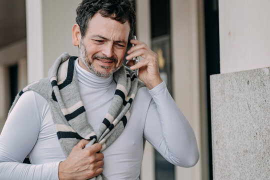 middle-aged man talking on the phone on the street