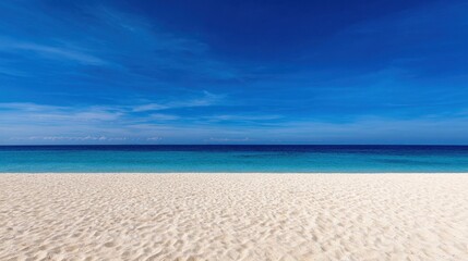 Fototapeta premium Serene beach landscape with pristine white sand and clear blue ocean under a bright sky