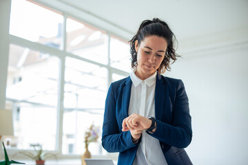 Businesswoman checking time on smart watch