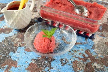 Homemade raspberry sorbet , scoop of raspberry ice cream, garnish with mint leaves