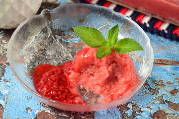 Homemade raspberry sorbet , scoop of raspberry ice cream, garnish with mint leaves
