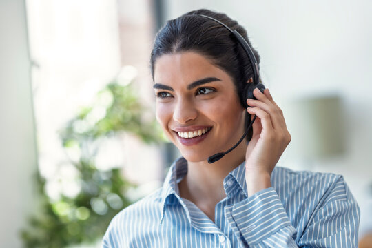 Smiling customer service representative using a headset in an office