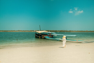 Scenic view of a female tourist walking on the sandy beach the Sand Bank in Funzi Island in Diani Beach, Kenya 