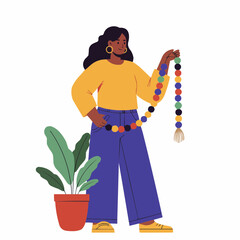 Black woman holding colorful wooden bead garland beside plant  
