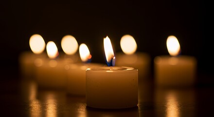 One Candle Burns Brightly Amidst a Gathering of Softly Glowing Flames