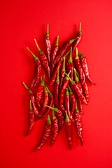 Vertical Arrangement of Red Chili Peppers on Red Surface