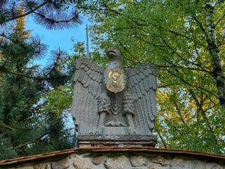 Eagle with the image of Our Lady Listening Patiently above the wall with the litany, in the garden of the Minor Basilica of Our Lady of Patience in Rokitno in Poland