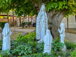 A figure of Mary and the children of Fatima (Jacenta, Lucia, and Frances) in the garden at the...