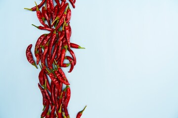 Vertical Stack of Chili Peppers on Blue Surface