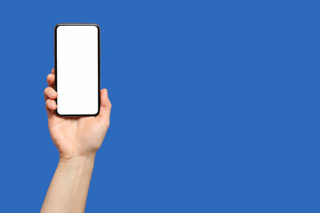 A hand presents a smartphone with a blank screen against a vivid blue background