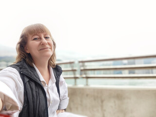 Blonde woman enjoying a leisurely moment during her Hong Kong travel adventure, capturing a selfie...
