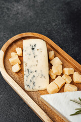 Delicious cheese platter featuring various cheese types on wooden board