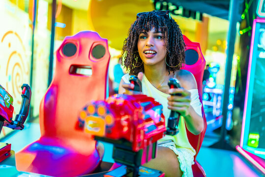 Young woman playing arcade racing game in a shopping mall