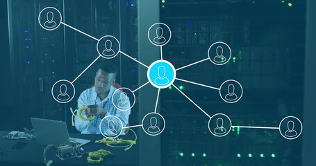 Technician wearing shirt connecting yellow Ethernet cables in server room, with laptop, copy space