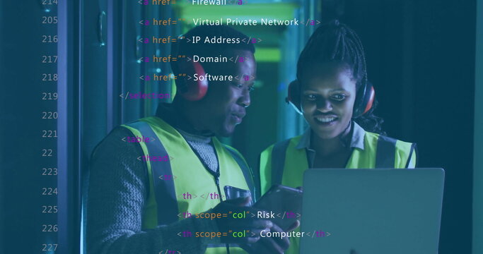 IT technicians in neon vests checking laptop code in server room, with headphones and server racks