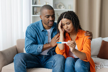 Infertility Problems. Portrait Of Upset Young Black Couple Looking At Negative Pregnancy Test While...