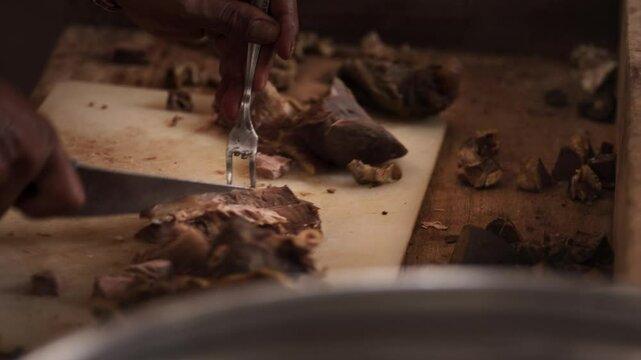 Close-Up of a Hand Slicing Meat at a Coto Makassar Stall &ndash; Traditional Indonesian Culinary Preparation