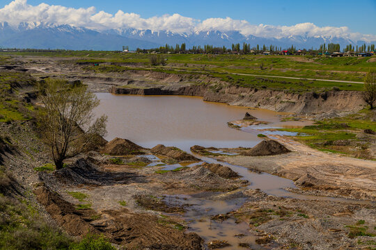 Serene rural landscape with tree alluvial quarry in mountain riverbed.