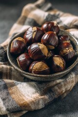 Bowl of roasted chestnuts on a plaid napkin, cozy indoor lighting