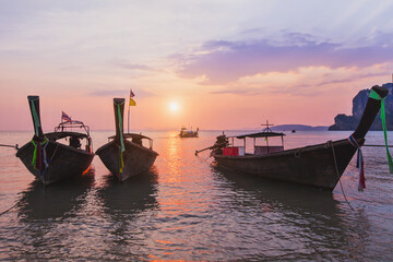 travel to Thailand, long-tail boats on Krabi beach, traditional boat silhouettes at sunset