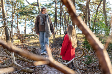 Two women walking in the forest. Forest. Nature. Female traversing fallen tree trunk.