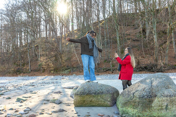 Happy friends walking by rock at beach. Two women on the rocks. Outdoors.