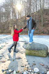 Happy friends walking by rock at beach. Two women on the rocks. Outdoors.