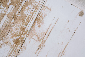 White wall with beige peeling texture and vertical damage marks from aging