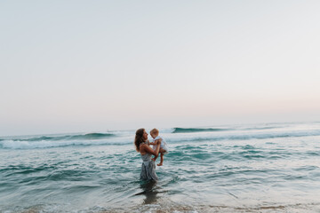 Happy mom and little child enjoying time together on beach holiday