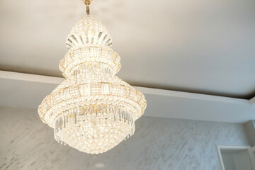 Elegant chandelier illuminating a sophisticated interior space at midday