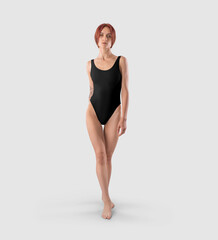 Template of a black one-piece swimsuit, on a slender redheaded girl with a tattoo, front view.