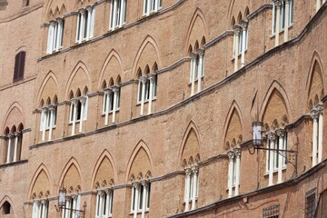 Obraz premium Old Italian houses in Siena, characterized by their terracotta and brick facades, showcasing the city's historic architecture, Italy