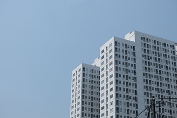 Obraz premium A shot of modern high-rise buildings with clean white facades against a clear blue sky, showcasing urban architecture.