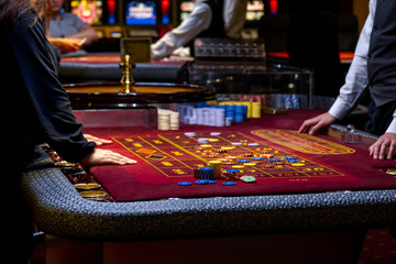 Close up of a Roulette Table. People play poker in the casino. Croupier behind gambling table in a...