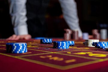 A man places a bet with chips in a casino. A player takes a lot of chips in a casino .Poker game in...