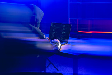 Mysterious Hacker Coding in Dark Environment with Laptop in Focus