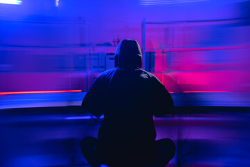 Intruder in Hooded Jacket Working on Computer Device in Dim Light