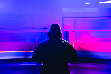 Dark Figure in Hoodie Surrounded by Abstract Digital Effects