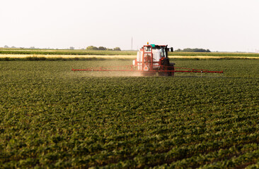 Tractor spraying soybean crops field