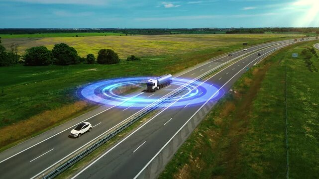 High-tech truck drives along a highway surrounded by glowing digital radar rings, symbolizing autonomous driving, unmanned vehicle technology, GPS tracking, and the future of smart transportation. 