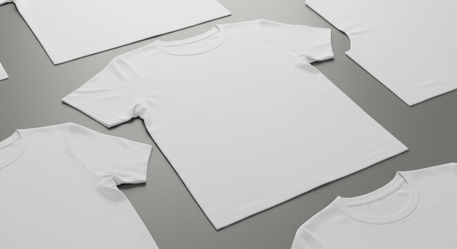 Several blank white t-shirts laid out on a gray surface, showcasing various angles and folds.