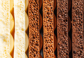 Layers of chocolate showcase varying textures and bubbles, highlighting dessert artistry.