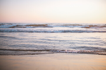 Gentle beach waves with pastel reflections and soft ocean light