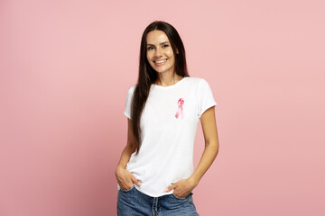 Smiling woman wearing pink ribbon on white t shirt supporting breast cancer awareness