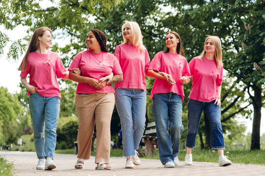 Women wearing pink ribbons walking together for breast cancer awareness - Powered by Adobe
